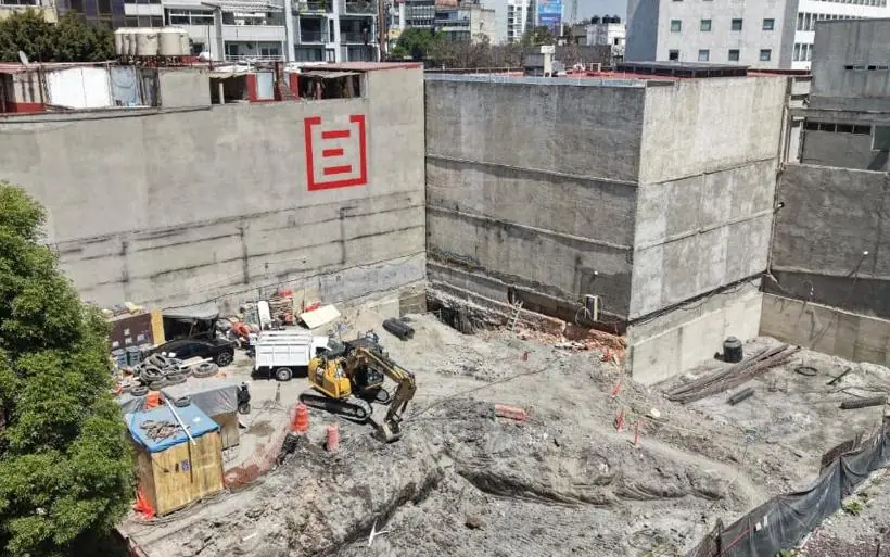 Excavadora cargando un camión en un predio urbano