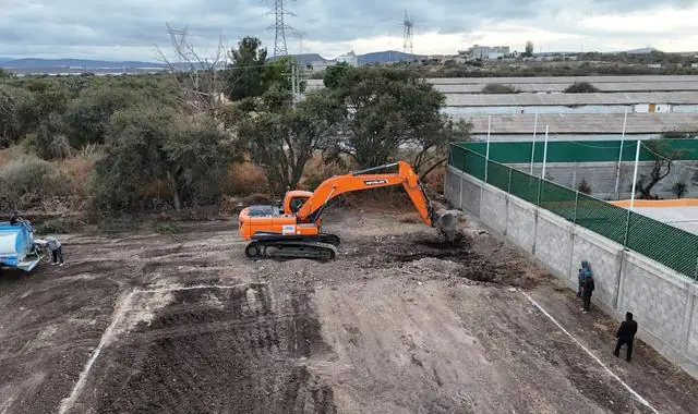 Retroexcavadora nivelando un terreno